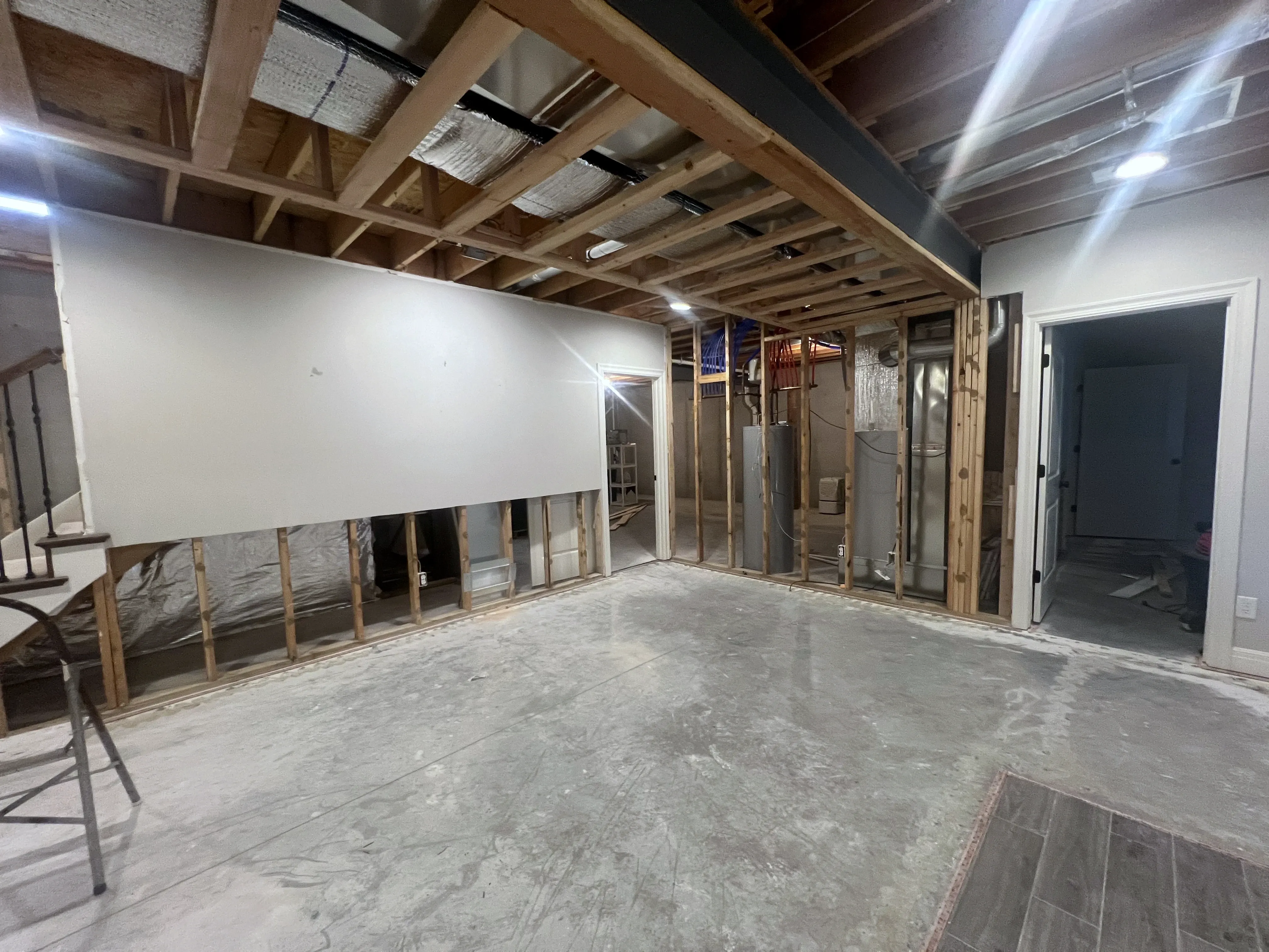 Unfinished basement with open framing and concrete floors before a Holden, Missouri whole home remodel