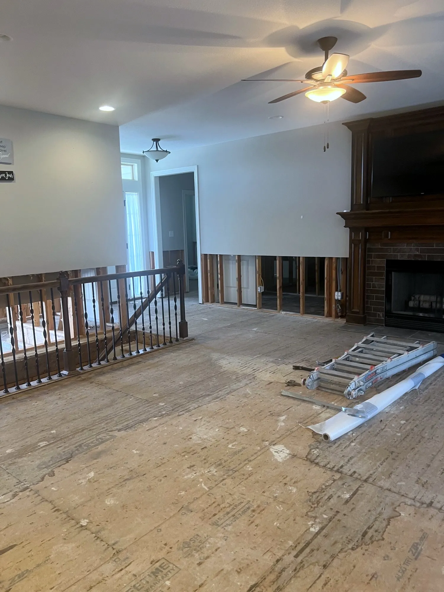 Main level living room stripped to bare subfloor before new hardwood in a Holden, Missouri whole home remodel