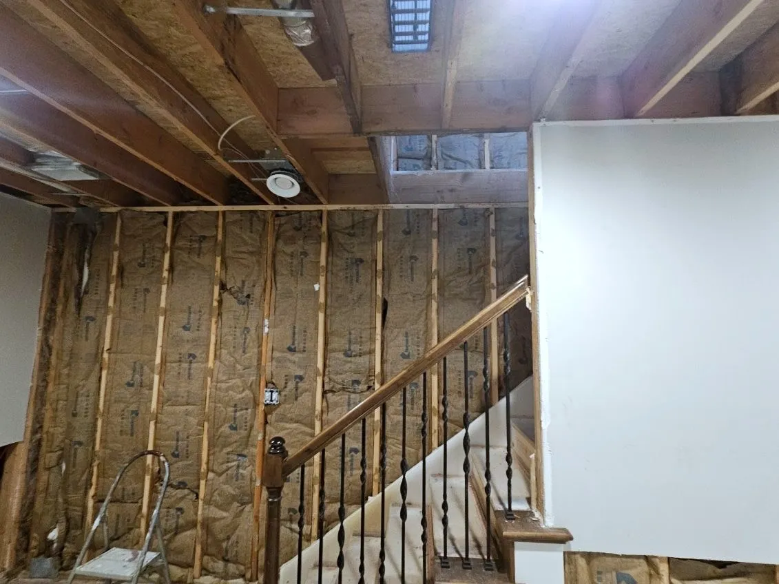 Wall insulation installed along the basement stairwell in a Holden, Missouri whole home remodel