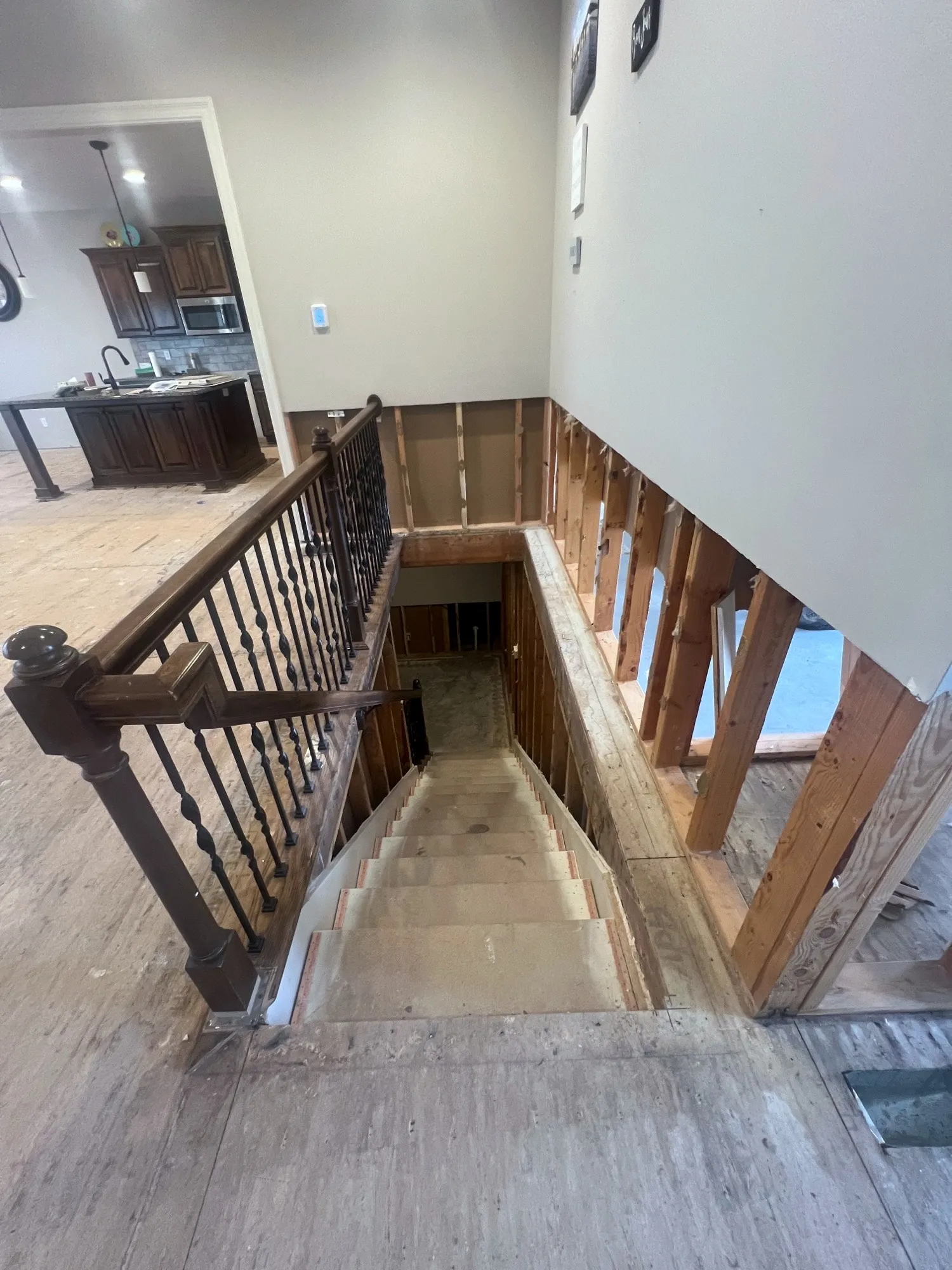 Staircase opening stripped to bare framing and subfloor in a Holden, Missouri whole home remodel