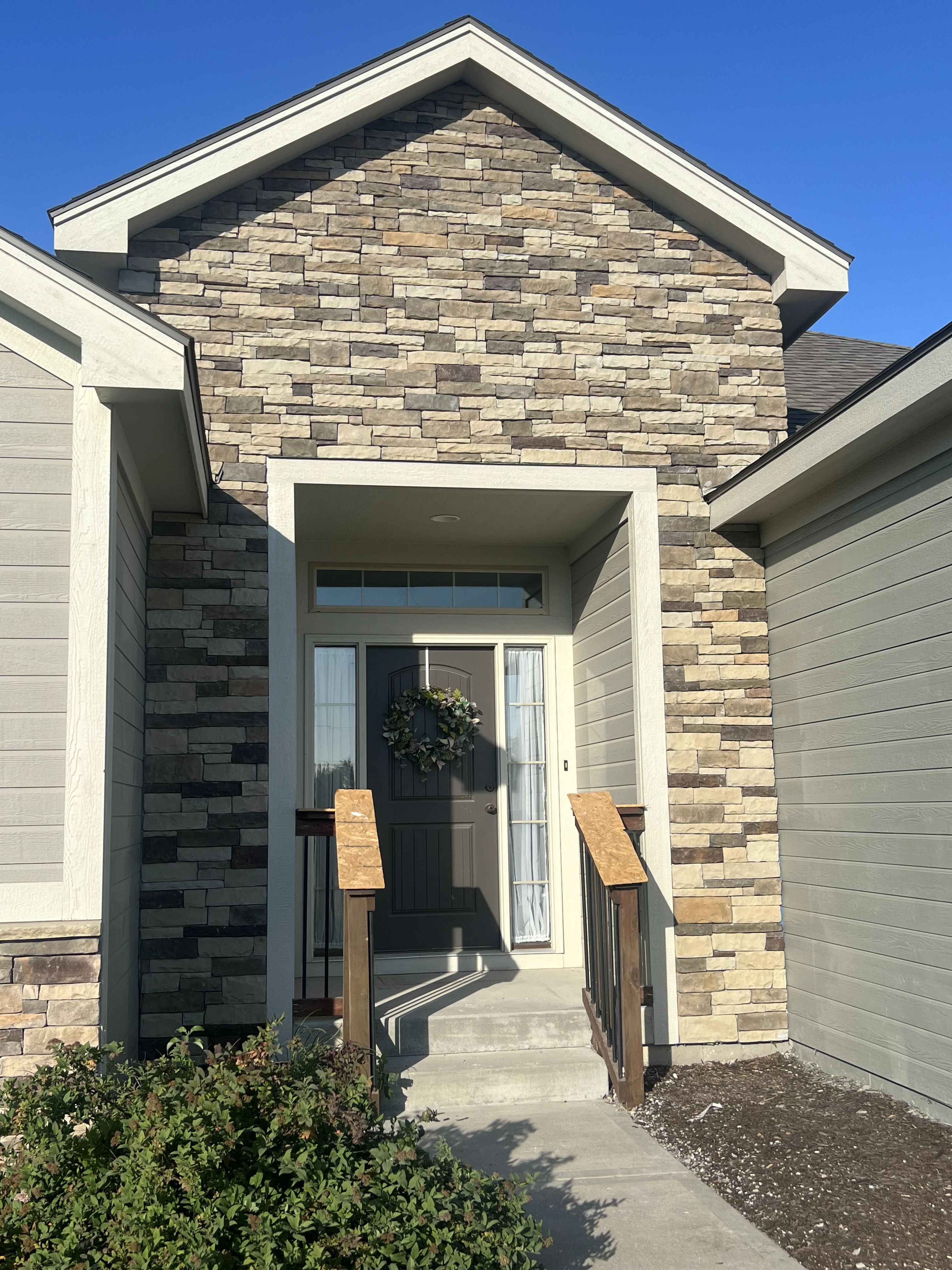 Finished front entry with a new stacked stone facade in a Holden, Missouri whole home remodel