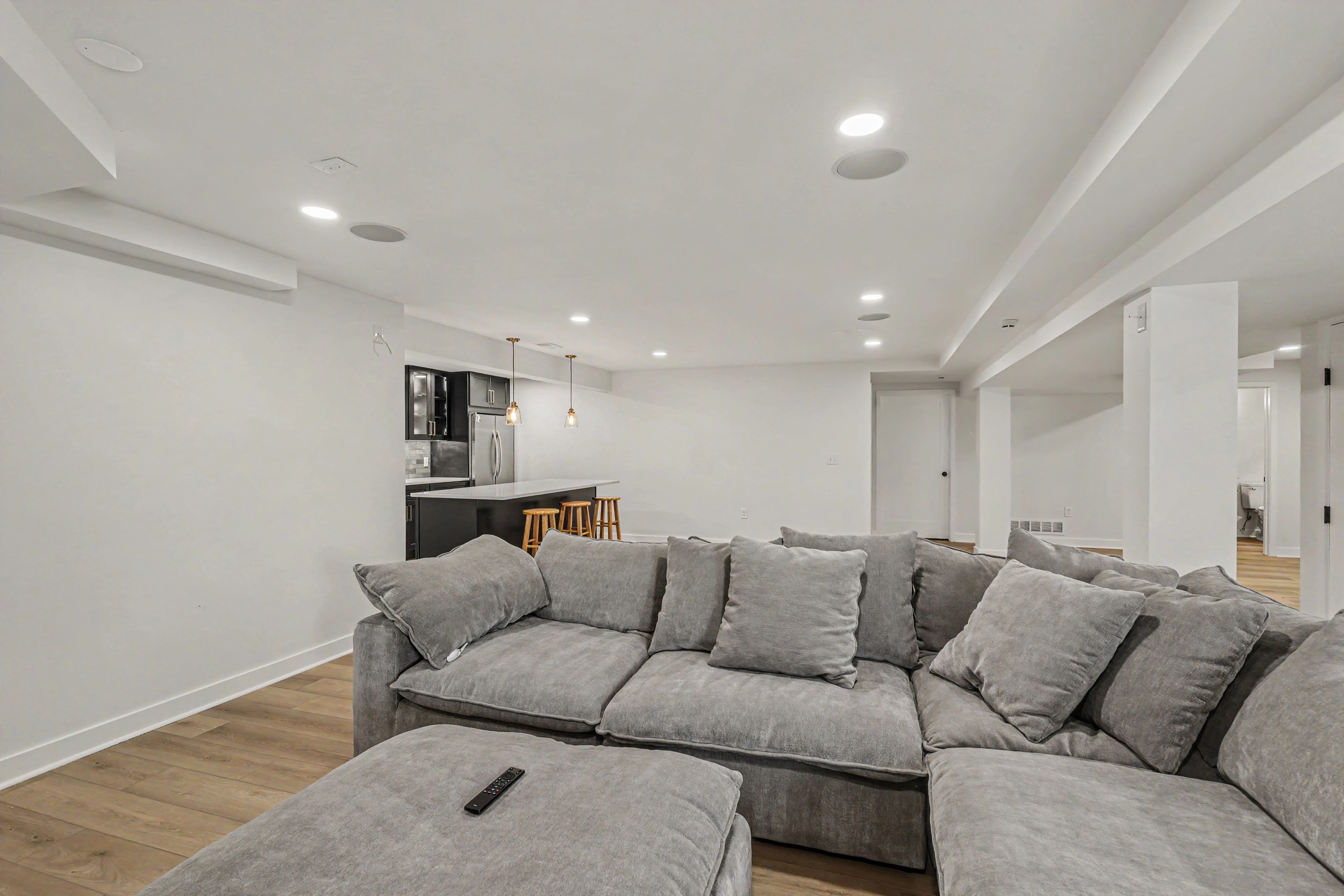 Open basement family room looking toward the custom kitchenette in a Prairie Village basement remodel