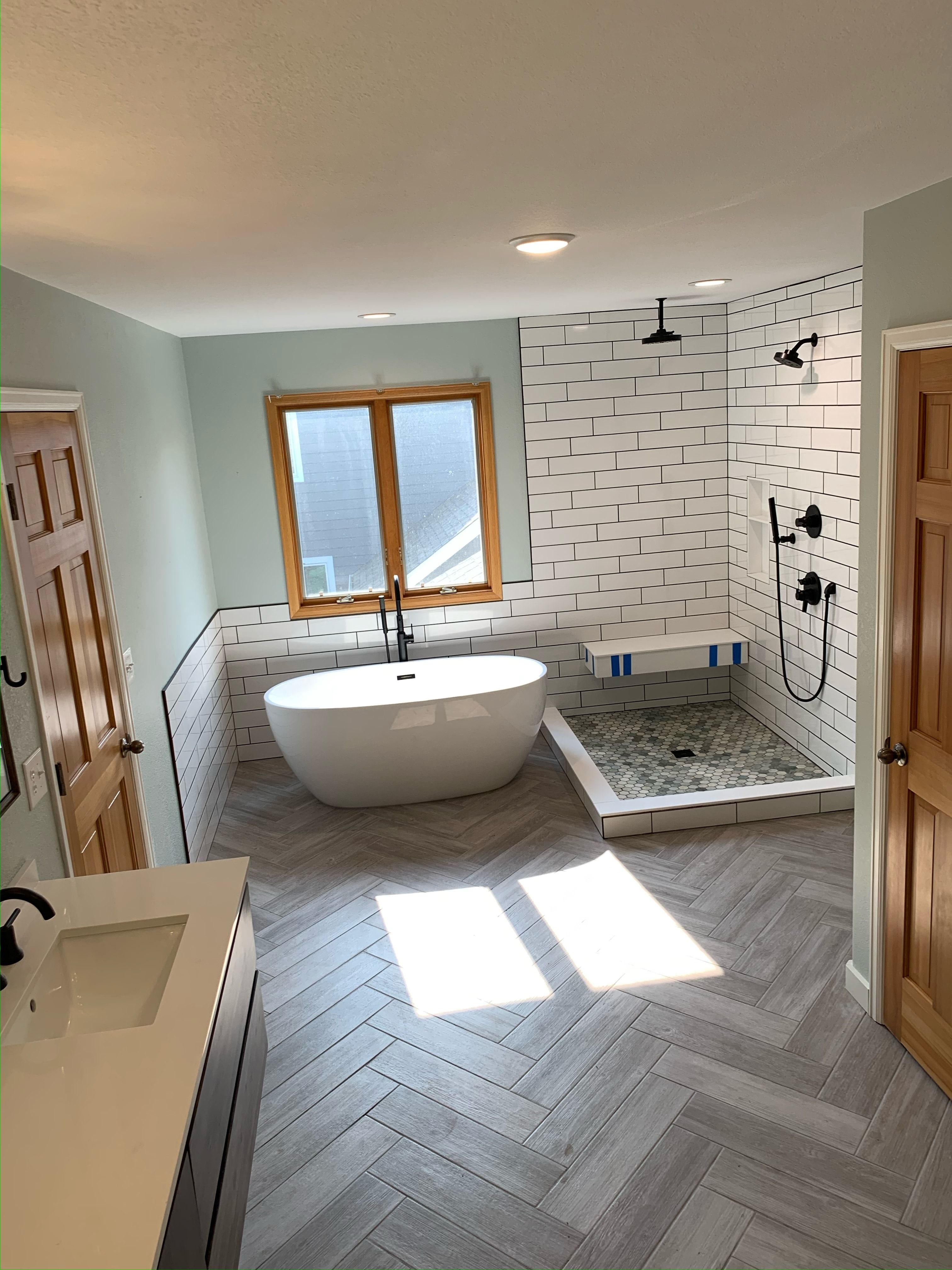 Finished bathroom remodel in Prairie Village by Resurrection Homes with a freestanding tub and tiled shower