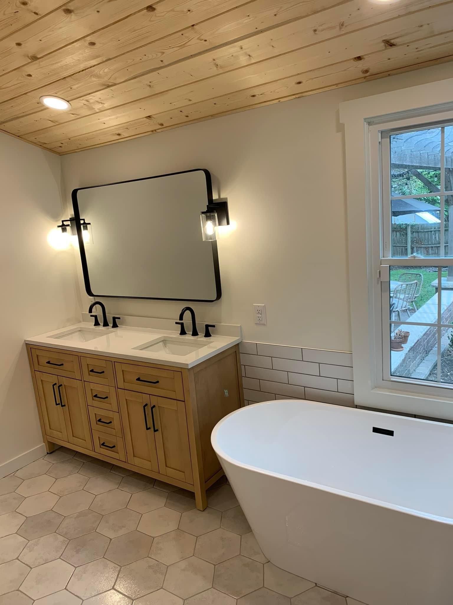 Freestanding tub, wood double vanity, and natural plank ceiling in a Prairie Village bathroom remodel