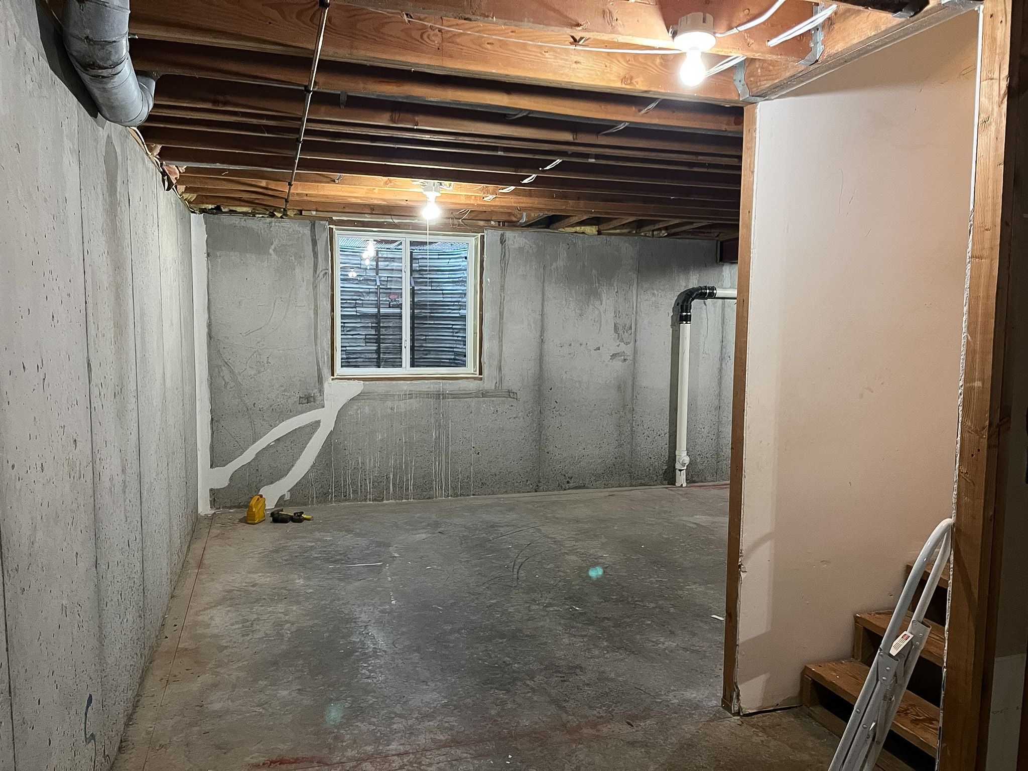 Bare foundation and exposed framing before a Raymore basement remodel.