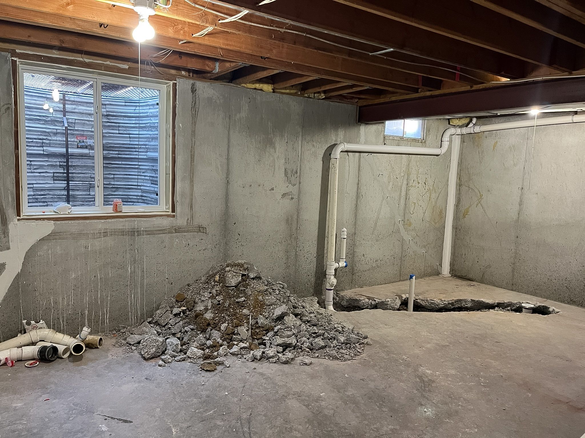 Rough plumbing run in the concrete for a basement bathroom remodel in Raymore.